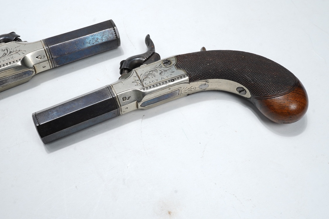 A pair of boxlock percussion pocket pistols with 4cm octagonal barrels, the frames engraved Lacy & Co., London, with London proof marks and rounded chequered walnut butts (2)